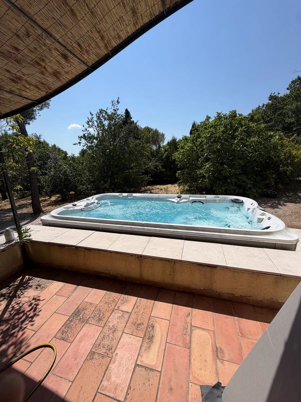 Spa Jacuzzi® encastré dans un jardin arboré